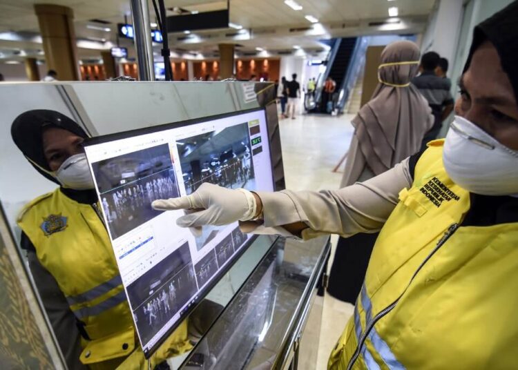 An Indonesian health officer checks the screen of a thermal scanner for passengers amid a deadly virus outbreak which began in the Chinese city of Wuhan, at the Lombok International airport in Praya, Central Lombok, West Nusa Tenggara on January 26, 2020. (Photo by MOH EL SASAKY / AFP)