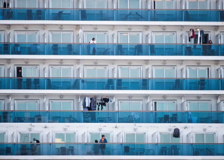 Passengers are seen on the balconies of the Diamond Princess cruise ship, with around 3,600 people quarantined onboard due to fears of the new coronavirus, at the Daikaku Pier Cruise Terminal in Yokohama port on February 12, 2020. - A further 39 people on board the Diamond Princess cruise ship off the Japan coast have tested positive for the COVID-19 coronavirus, authorities said on February 12, as thousands more steel themselves for a second week in quarantine. (Photo by Behrouz MEHRI / AFP)