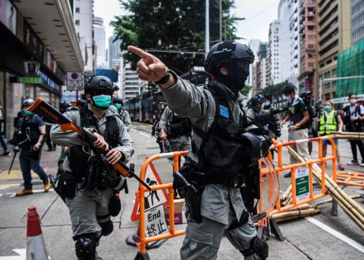 Riot police clear up debris left by protesters attending a pro-democracy rally against a proposed new security law in Hong Kong on May 24, 2020. - Police fired tear gas and water cannon at thousands of Hong Kong pro-democracy protesters who gathered on May 24 against a controversial security law proposed by China, in the most intense clashes in months. (Photo by ANTHONY WALLACE / AFP)