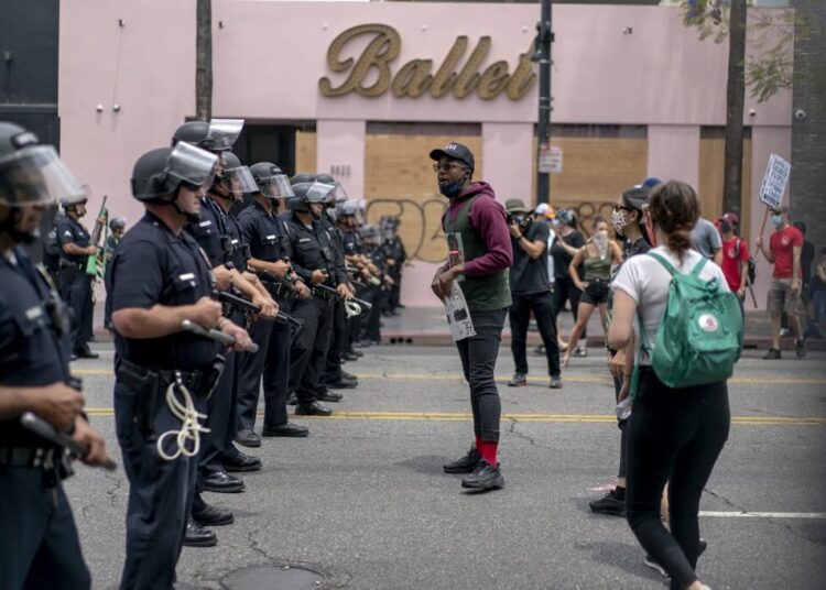 Protesters face police in Hollywood during a demonstration over the death of George Floyd while in Minneapolis Police custody, in Los Angeles, California, June 2, 2020. - Anti-racism protests have put several US cities under curfew to suppress rioting, following the death of George Floyd. (Photo by Kyle Grillot / AFP)