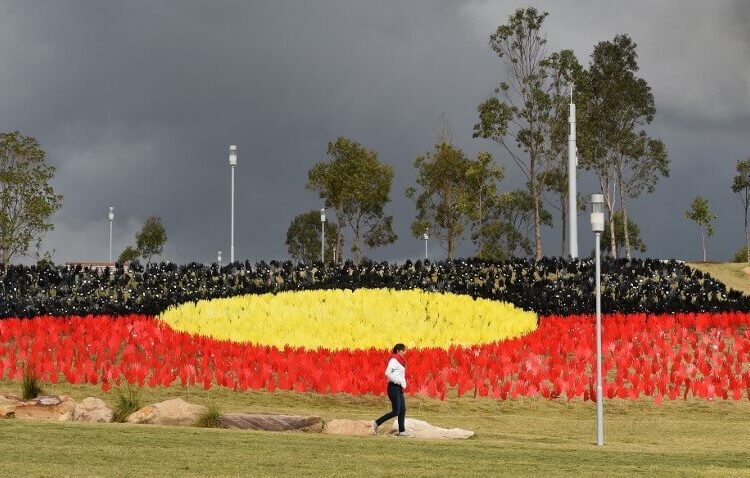 A woman passes a huge art installation called 'Sea of Hands' which consists of thousands of hands in the colours of the Aboriginal flag  red, yellow, black. - Part of National Reconciliation Week 2016, the installation is for Australians to reflect on Australias national identity and the place of Aboriginal and Torres Strait Islander histories and cultures in the nations story. (Photo by William WEST / AFP)