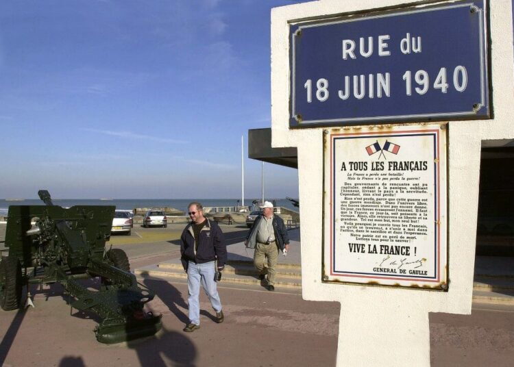des touristes passent devant une rue baptisée en hommage au général de Gaulle et son appel du 18 juin 1940, le 15 octobre 2003 sur le site d'Arromanches, l'une des plages du débarquement de juin 1944 où les Alliés installèrent un port articifiel. (Photo by MYCHELE DANIAU / AFP)