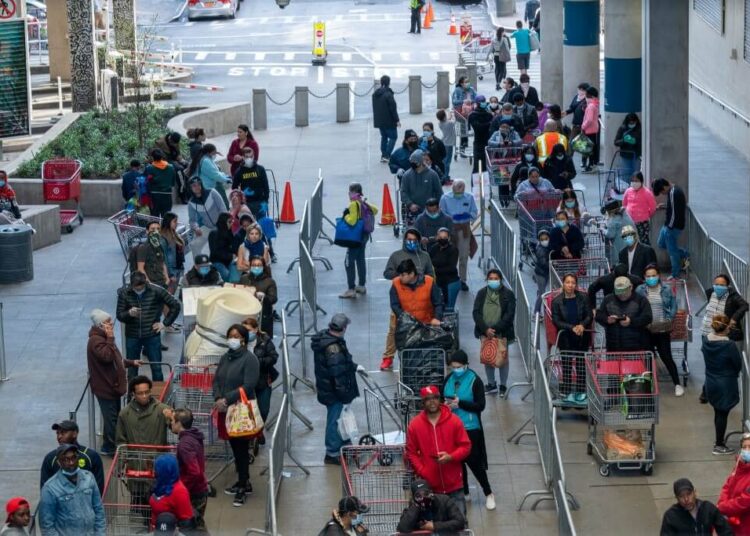 NEW YORK, NY - APRIL 08: People stand in line at East River Plaza for shopping at Costco and Target on April 8, 2020 in New York City. Businesses that remain open continue to encourage social distancing, which health experts say is in the early stages of showing results, amid the coronavirus pandemic.   David Dee Delgado/Getty Images/AFP