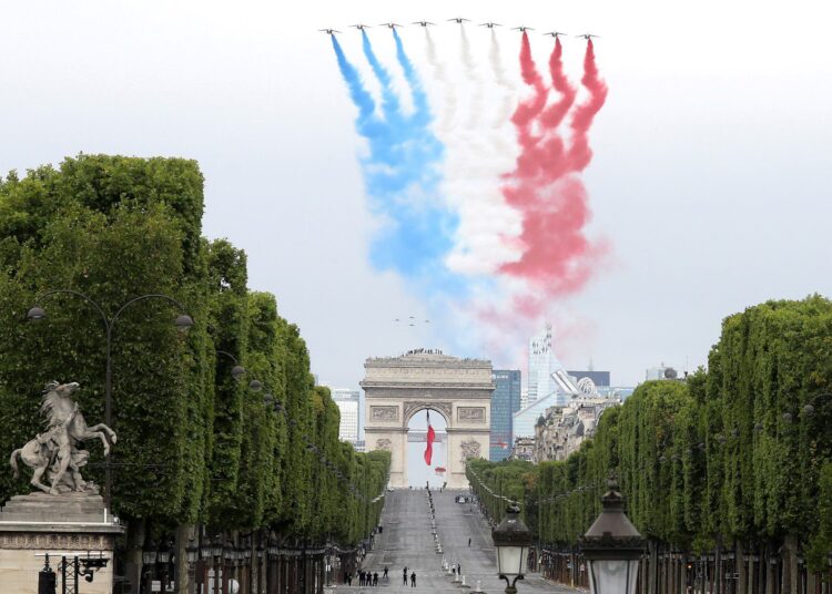 French elite acrobatic flying team "Patrouille de France" (PAF) performs a flying display of the French national flag over the Arc de Triomphe during annual Bastille Day military ceremony on the Place de la Concorde in Paris, on July 14, 2020. - France holds a reduced version of its traditional Bastille Day parade this year due to safety measures over the COVID-19 (novel coronavirus) pandemic, and with the country's national day celebrations including a homage to health workers and others fighting the outbreak. (Photo by Ludovic Marin / POOL / AFP)