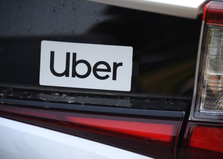 An Uber sticker is seen on a car at the start of a protest by ride share drivers on August 20, 2020 in Los Angeles, California. - Rideshare service rivals Uber and Lyft were given a temporary reprieve on August 20 from having to reclassify drivers as employees in their home state of California by August 21. (Photo by Robyn Beck / AFP)