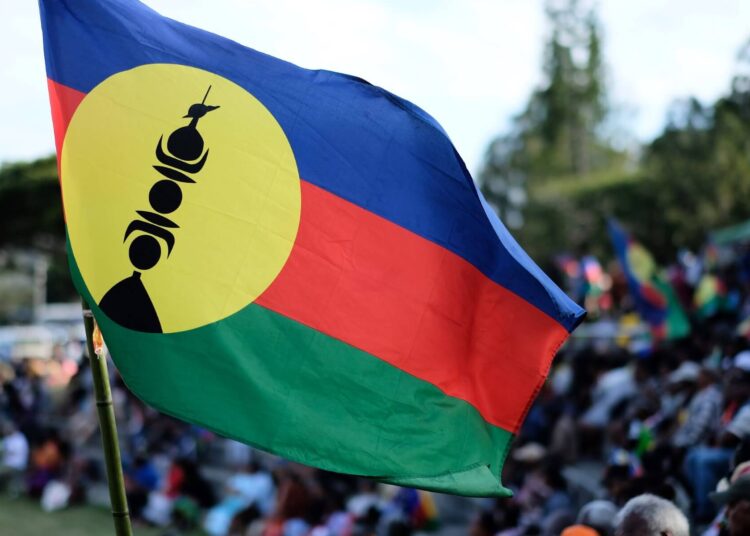 A flag of the Socialist Kanak National Liberation Front (FLNKS) flies during the last meeting of the FLNKS campaign for the "YES" to the self-determination referendum of New Caledonia, in Noumea on October 1, 2020. - New Caledonia, a remote island territory belonging to France in the southwestern Pacific, will hold a referendum vote on independence on October 4, 2020 for the second time in two years. (Photo by Theo Rouby / AFP)