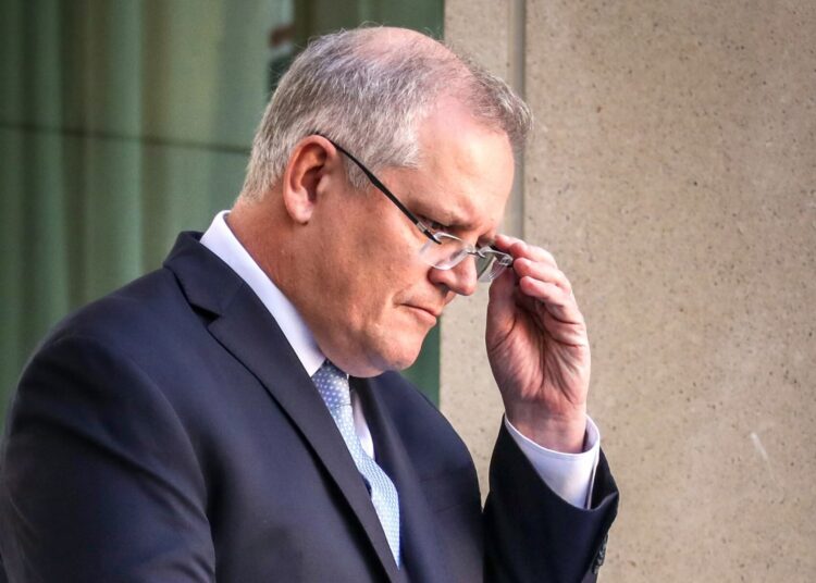 (FILES) This file photo taken on March 22, 2020 shows Australia's Prime Minister Scott Morrison reacting during a press conference at Australia's Parliament House in Canberra. - A former Australian government staffer has said she was raped in a minister's office in parliament and failed by her bosses after coming forward, prompting an apology from Morrison on February 16, 2021. (Photo by DAVID GRAY / AFP)