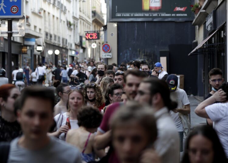 People queue in a street to attend the Kaamelott premiere screening at Grand Rex cinema in Paris, on July 20, 2021. - Kaamelott is directed by French Alexandre Astier and will be released on July 21, 2021. (Photo by GEOFFROY VAN DER HASSELT / AFP)