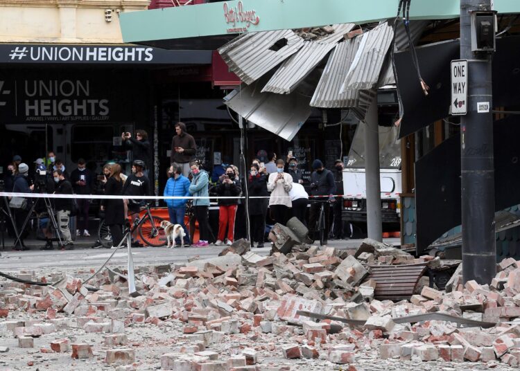 Residents gather near a damaged building in the popular shopping Chappel Street in Melbourne on September 22, 2021, after a 5.9 magnitude earthquake. (Photo by William WEST / AFP)