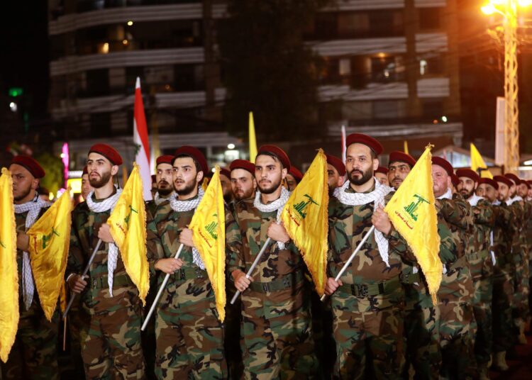 (FILES) This file photo taken on May 31, 2019 shows fighters with the Lebanese Shiite Hezbollah party, carrying flags as they parade in a southern suburb of the capital Beirut, to mark the al-Quds (Jerusalem) International Day. - Australia on November 24, 2021 listed all of Hezbollah as a "terrorist organisation", extending an existing ban on armed units to the entire organisation, which wields considerable power over Lebanon. (Photo by Anwar AMRO / AFP)