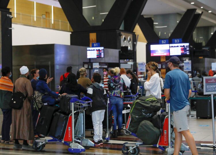 Travellers queue at a check-in counter at OR Tambo International Airport in Johannesburg on November 27, 2021, after several countries banned flights from South Africa following the discovery of a new Covid-19 variant Omicron. - A flurry of countries around the world have banned ban flights from southern Africa following the discovery of the variant, including the United States, Canada, Australia,Thailand, Brazil and several European countries. The main countries targeted by the shutdown include South Africa, Botswana, eSwatini (Swaziland), Lesotho, Namibia, Zambia, Mozambique, Malawi and Zimbabwe. (Photo by Phill Magakoe / AFP)