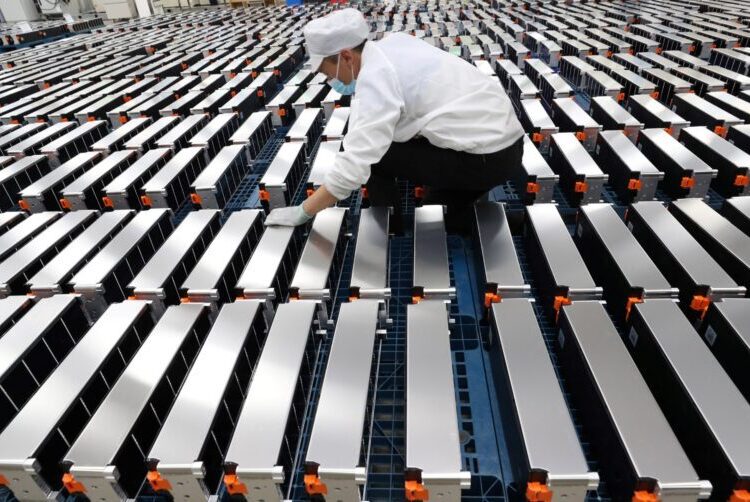 (FILES) This file photo taken on March 12, 2021 shows a worker with car batteries at a factory for Xinwangda Electric Vehicle Battery Co. Ltd, which makes lithium batteries for electric cars and other uses, in Nanjing in China's eastern Jiangsu province. - Lithium, cobalt and nickel, the metals that are essential to the manufacture of the electric batteries that will replace the combustion engines that contribute to global warming, are so sought after that Europe is preparing to open mines and refineries to try to reduce its dependence on imports. (Photo by STR / AFP) / China OUT / NO USE AFTER FEBRUARY 12, 2022 19:42:11 GMT - CHINA OUT