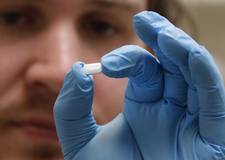 A pharmacy tech holds a pill of Hydroxychloroquine at Rock Canyon Pharmacy in Provo, Utah, on May 20, 2020. - US President Donald Trump announced May 18 he has been taking hydroxychloroquine for almost two weeks as a preventative measure against COVID-19. (Photo by GEORGE FREY / AFP)