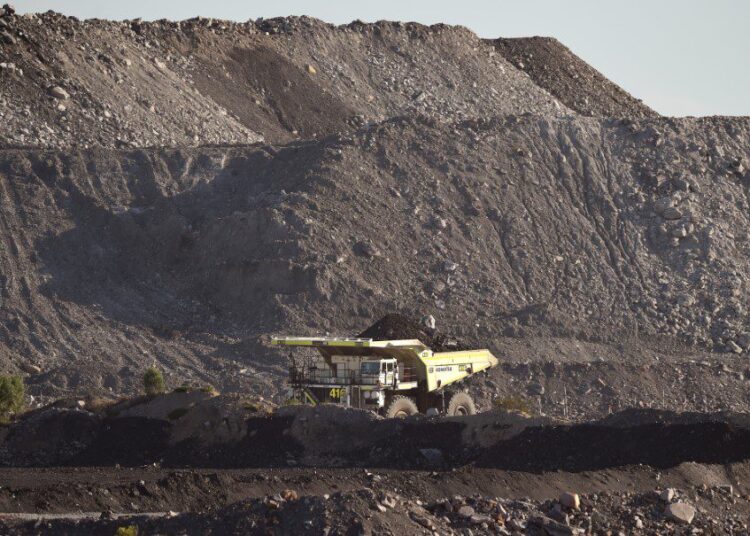 (FILES) This file photo taken on November 18, 2015 shows a large truck driving through an open-cut coal mine in Singleton in the Hunter Valley north of Sydney. - Coal-rich Australia on October 26, 2021 unveiled a much-delayed 2050 net zero emissions target, but shied away from setting more ambitious goals ahead of a landmark UN climate summit. (Photo by William WEST / AFP)