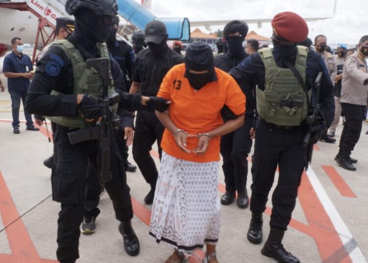 (FILES) This file photo taken on December 16, 2020 shows police escorting Zulkarnaen, a senior leader of the Al-Qaeda-linked Jemaah Islamiyah (JI), who had been on the run for his alleged role in the 2002 Bali bombings, upon arrival at Jakartas Soekarno-Hatta International Airport in Tangerang. - An Indonesian court on January 19, 2022 sentenced an Al-Qaeda-linked Islamist militant to 15 years in prison over his role in the 2002 bombings that killed 202 people on the resort island of Bali. (Photo by FAJRIN RAHARJO / AFP) / NO USE AFTER FEBRUARY 18, 2022 16:00:00 GMT