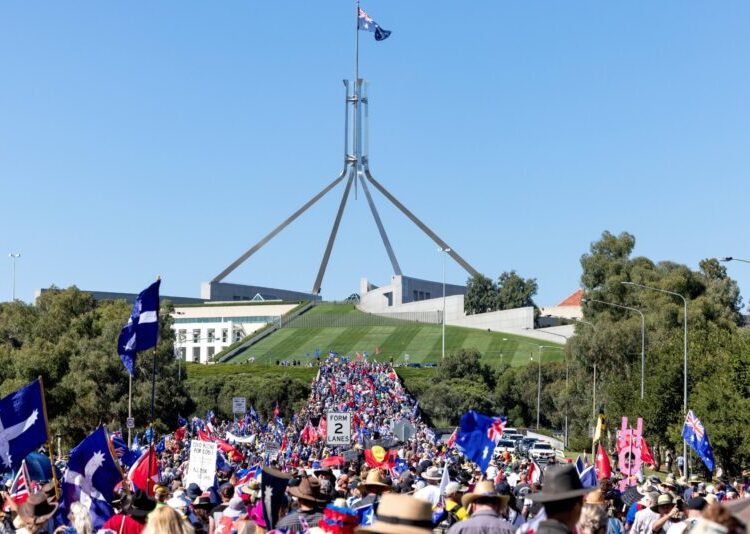 Thousands of protesters march towards the parliament building in Canberra on February 12, 2022, to decry Covid-19 vaccine mandates, the latest in a string of rallies against pandemic restrictions around the world. (Photo by STR / AFP)