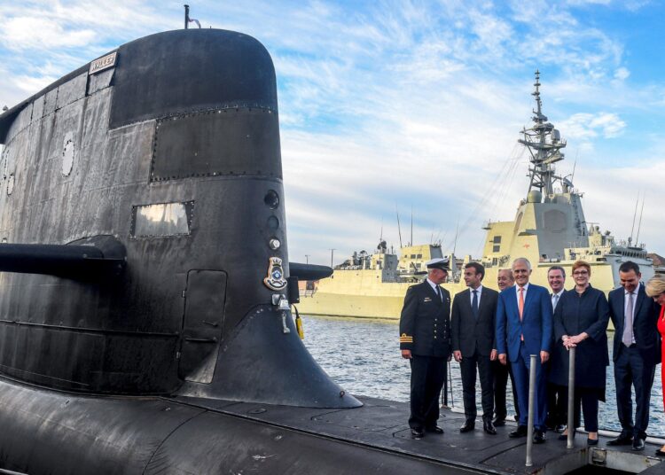 (FILES) A file photo taken on May 2, 2018 shows French President Emmanuel Macron (2/L) and Australian Prime Minister Malcolm Turnbull (C) standing on the deck of HMAS Waller, a Collins-class submarine operated by the Royal Australian Navy, at Garden Island in Sydney. - Former Australian leader Malcolm Turnbull said on September 29, 2021 his successor "deliberately deceived" France when he scrapped a multi-billion-euro submarine deal with Paris in favour of nuclear-powered US or British alternatives. (Photo by BRENDAN ESPOSITO / POOL / AFP) / NO USE AFTER OCTOBER 29, 2021 03:57:41 GMT