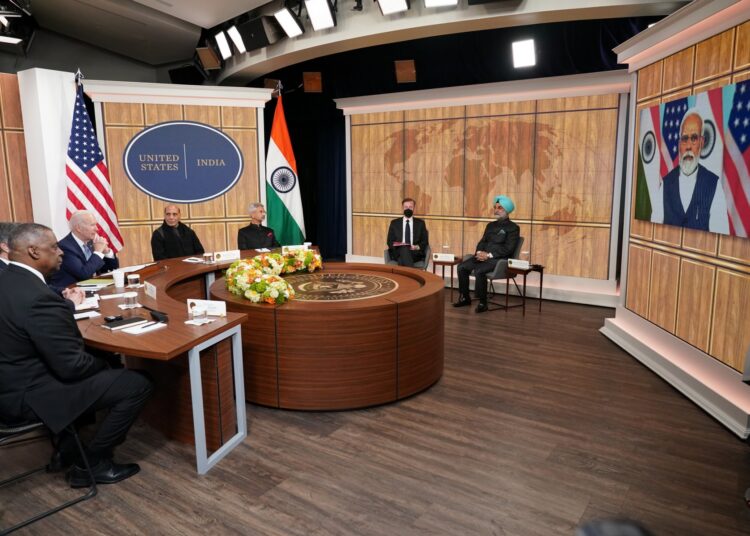 US President Joe Biden (C), alongside US Secretary of Defense Lloyd Austin (L) and India's Minister of Defense Rajnath Singh (3L), takes part in a virtual meeting with India's Prime Minister Narendra Modi in the South Court Auditorium of the Eisenhower Executive Office Building, next to the White House, in Washington, DC, on April 11, 2022. (Photo by MANDEL NGAN / AFP)