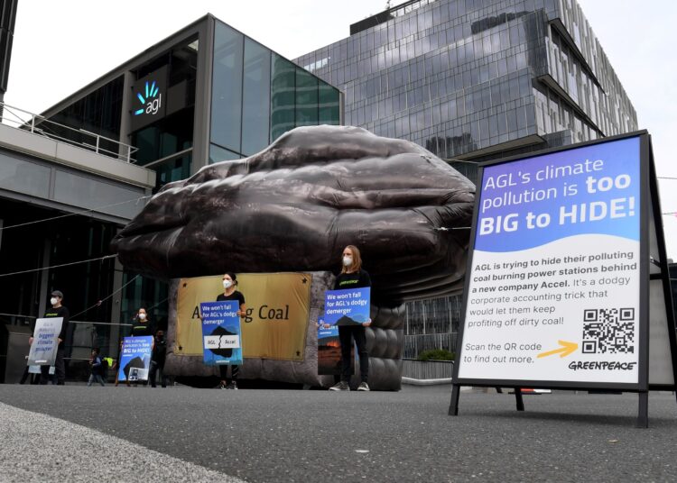 A giant inflatable depicting a piece of coal erected by Greenpeace stands outside Australian energy company AGL in Melbourne on March 28, 2022. (Photo by William WEST / AFP)