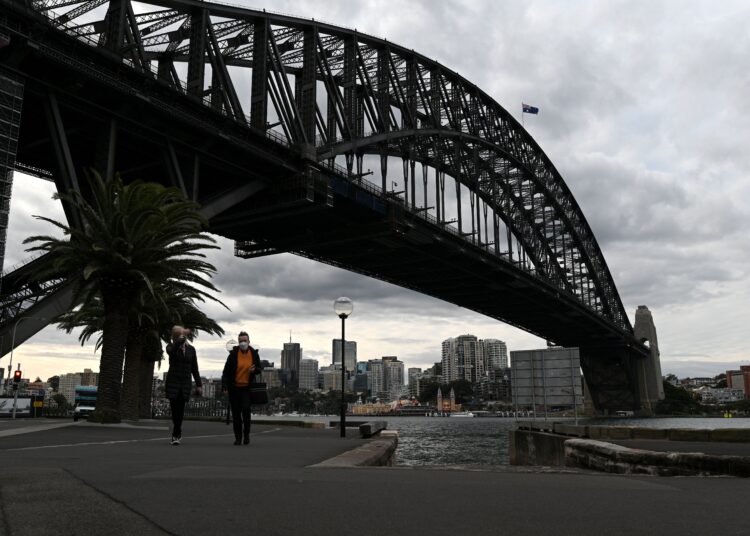 Cyclists ride along the quiet walkway along Harbour Bridge in Sydney on July 19, 2021, amid a lockdown in Melbourne and Sydney as Australia seeks to contain a surge in coronavirus cases. (Photo by Saeed KHAN / AFP)