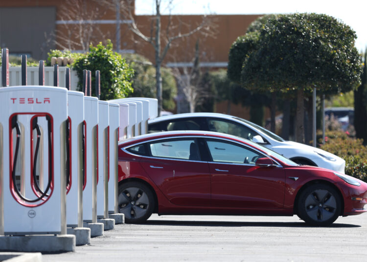 PETALUMA, CALIFORNIA - MARCH 09: A Tesla car recharges its battery at the Petaluma Supercharger on March 09, 2022 in Petaluma, California. With oil prices continuing to soar, shares for companies in the electric vehicle sector are rising as consumers look to trade their gas powered cars in for electric vehicles.   Justin Sullivan/Getty Images/AFP (Photo by JUSTIN SULLIVAN / GETTY IMAGES NORTH AMERICA / Getty Images via AFP)