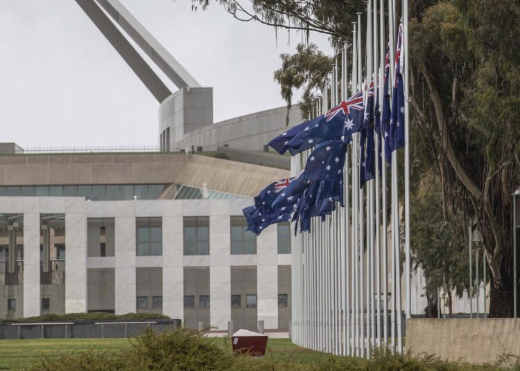 Australian flags fly at half-mast outside Parliament House in Canberra on September 9, 2022. - Queen Elizabeth II, the longest-serving monarch in British history and an icon instantly recognisable to billions of people around the world, died at her Scottish Highland retreat on September 8 at the age of 96. (Photo by STR / AFP)