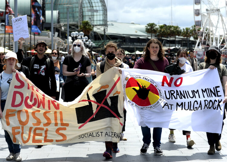 Demonstrator holding banners take part in a protest rally against the International Mining and Resources Conference (IMARC) held at the International Convention Centre in Sydney on November 4, 2022. (Photo by Muhammad FAROOQ / AFP)