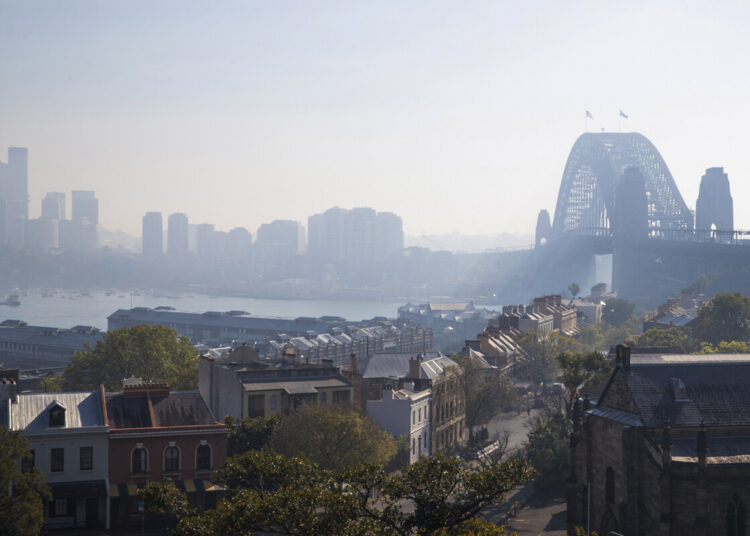 The Sydney Harbour Bridge is seen shrouded by smoke in Sydney on September 13, 2023, as a smoky haze blankets Australia's scenic Sydney Harbour, after a ring of controlled blazes burned on the city's fringes in preparation for the looming bushfire season. (Photo by Steve CHRISTO / AFP)