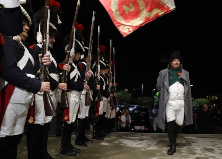 A performer dressed as late French emperor Napoleon I (R) and other performers dressed as Imperial Guards (L) welcome spectators at the Ellipse cinema in Ajaccio on November 21, 2023 for the screening of the film Napoleon on the French Mediterranean island of Corsica. (Photo by Pascal POCHARD-CASABIANCA / AFP)