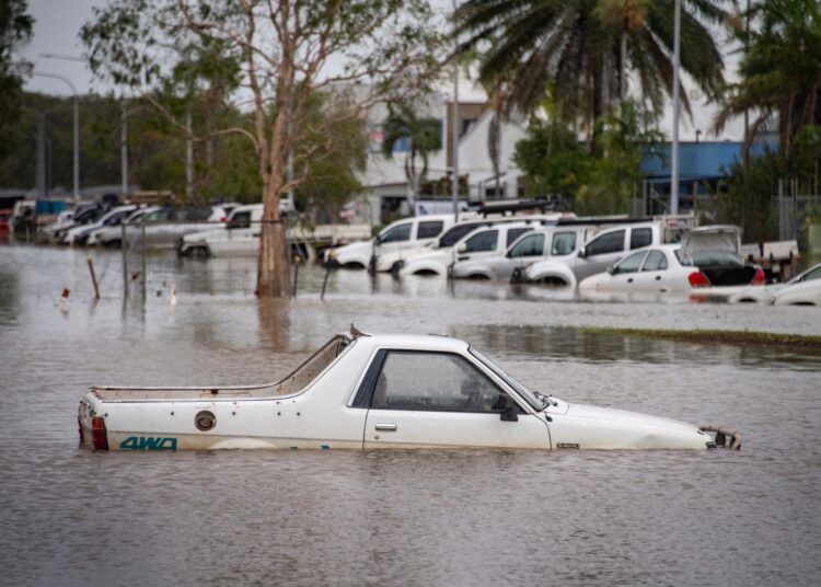 This picture shows cars amid floodwaters at Cairns Airport in Cairns on December 18, 2023. - Flash floods swamped northeastern Australia on December 18, with raging waters severing roads and flushing crocodiles into towns. (Photo by Brian CASSEY / AFP)